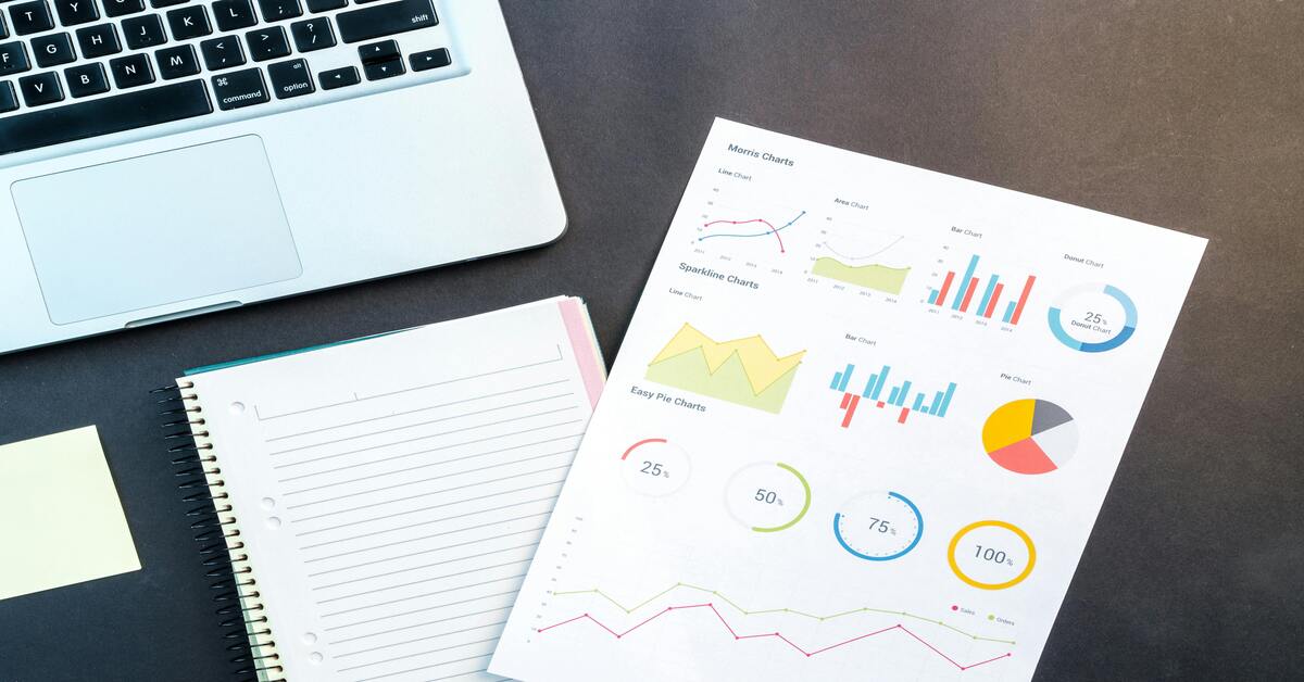"Remote digital marketing workspace in Gurugram featuring laptop, notebook, and printed data visualizations for financial strategy and content planning"